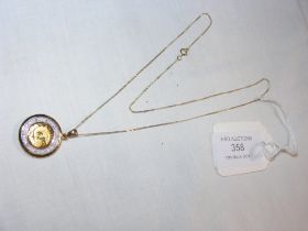 A gold pendant in circular mount on chain