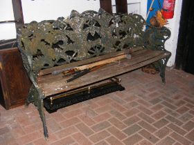 A heavy cast metal garden bench with leaf design -