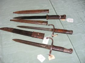 Three assorted bayonets in scabbards