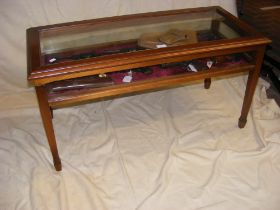 A hardwood low display cabinet with bevelled glass