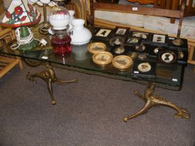 A rectangular glass coffee table with stylized gil