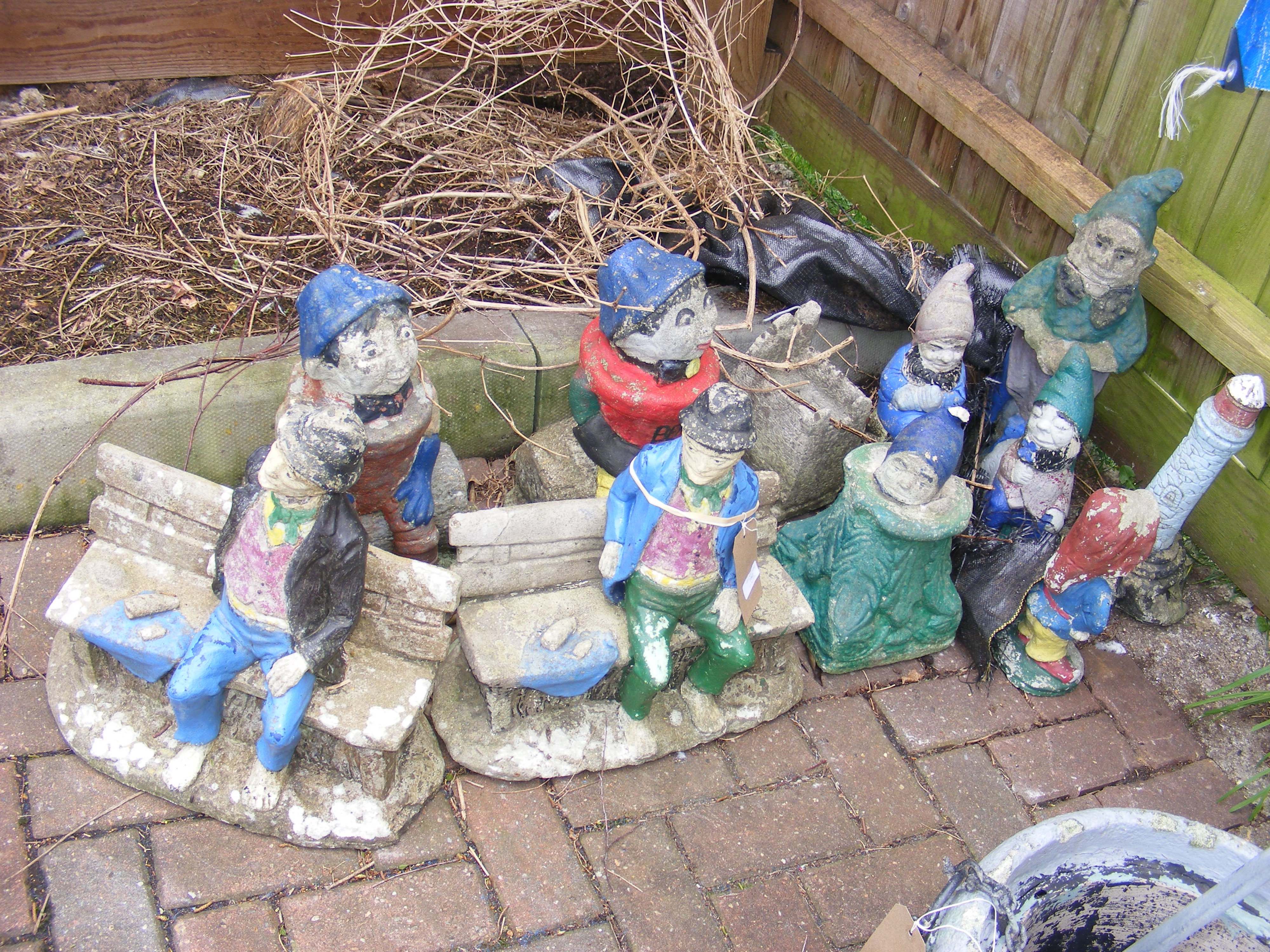 Assorted garden gnomes and ornaments, some painted