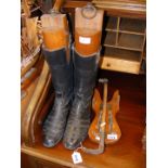 Black leather riding boots, together with wooden s