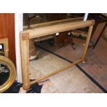 An antique overmantel mirror in stripped pine fram