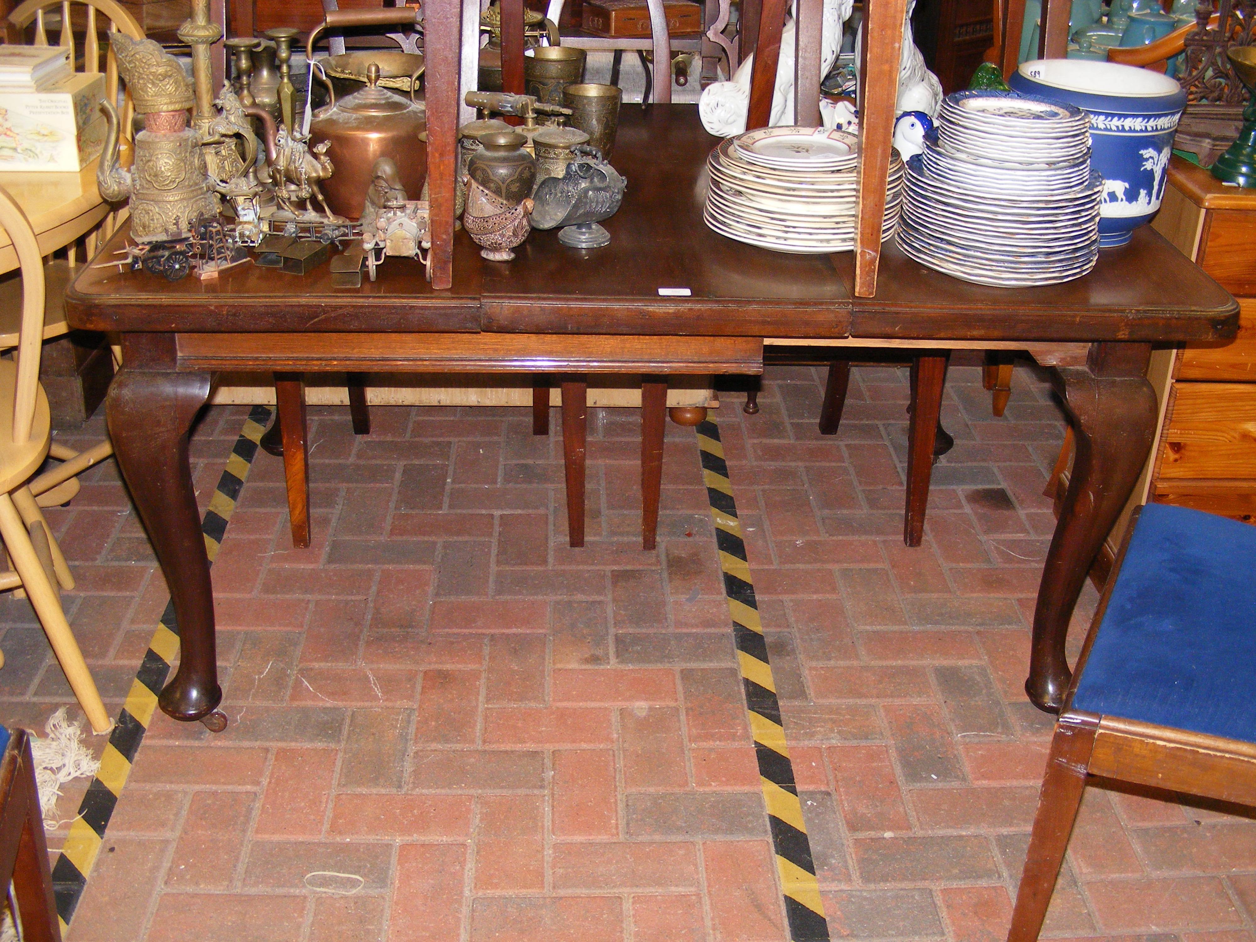 A mahogany extending dining table on cabriole supp