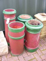 Four chimney pots painted burgundy red and green