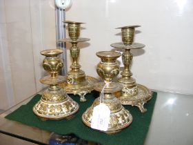 A pair of decorative brass candlesticks, together