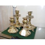 A pair of decorative brass candlesticks, together