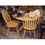 A circular light wood kitchen table with four hoop