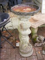 A garden birdbath of boy and fish form