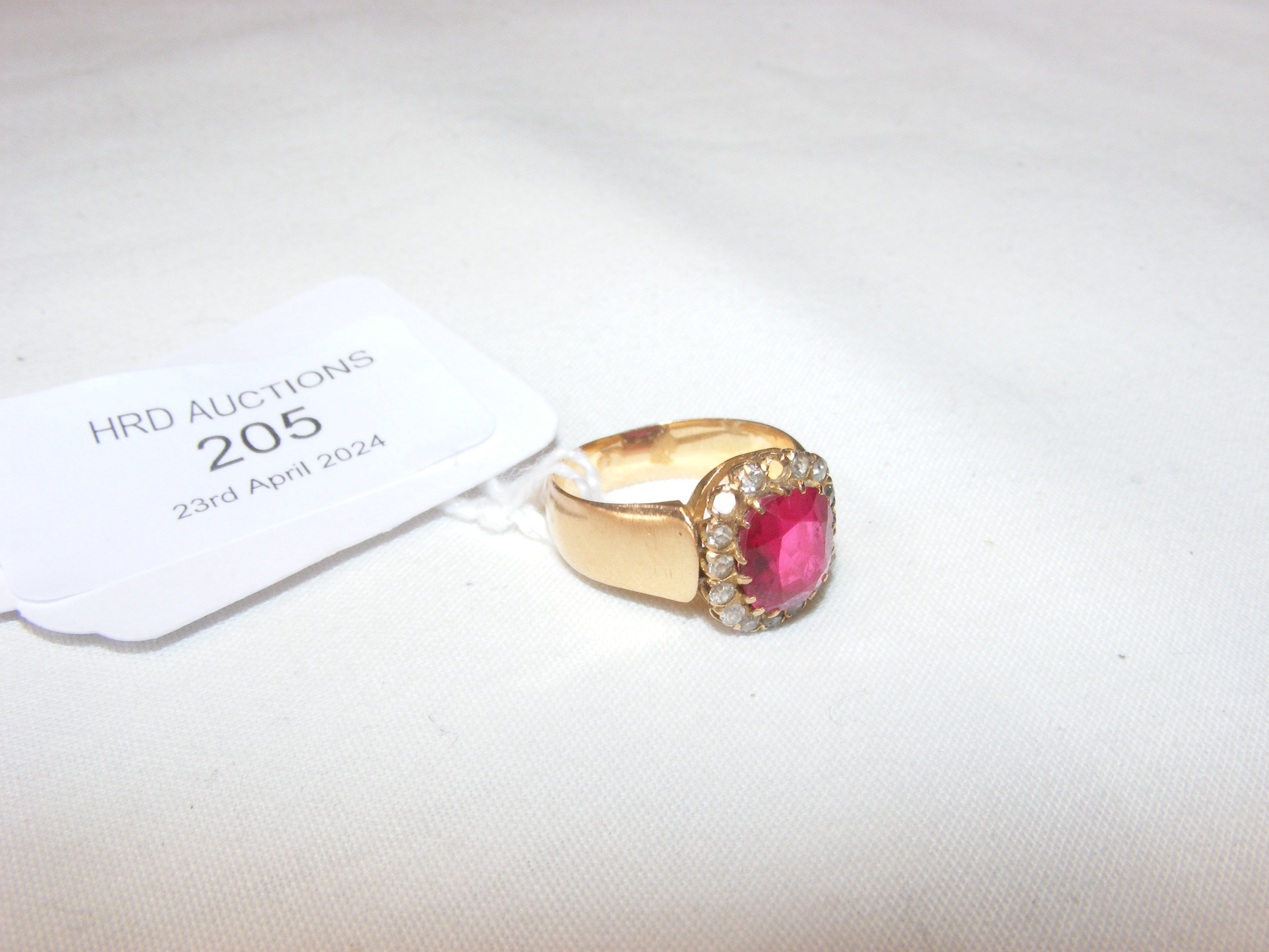 An unmarked yellow metal ring set with ruby and di