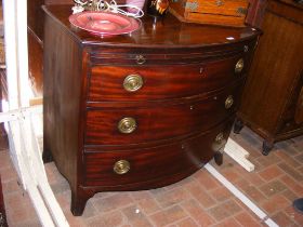 An early 19th century bow fronted mahogany chest w