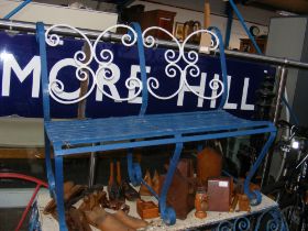 A wrought iron garden bench painted blue and white