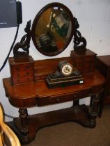 An antique mahogany dressing table with oval swing