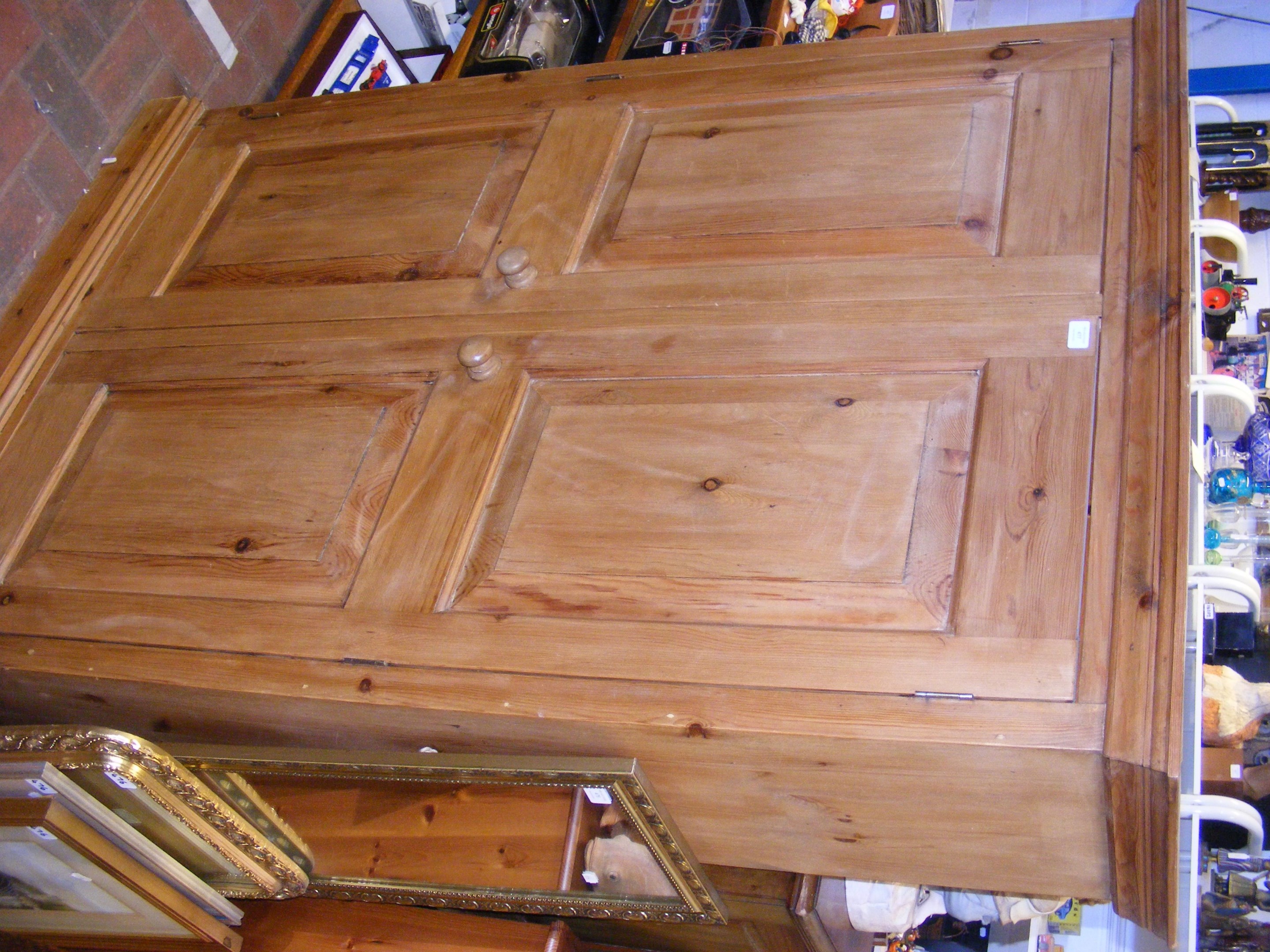 A pine two door cupboard - with shelves to the int