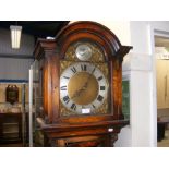 A 1920's oak long case clock with arched brass dia