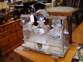 A silver plated tantalus with three decanters