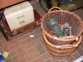 A vintage bread bin, suitcase, two wicker baskets,