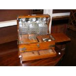 An oak tantalus with three cut glass bottles - wid