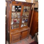 An antique oak display cabinet with cupboards belo