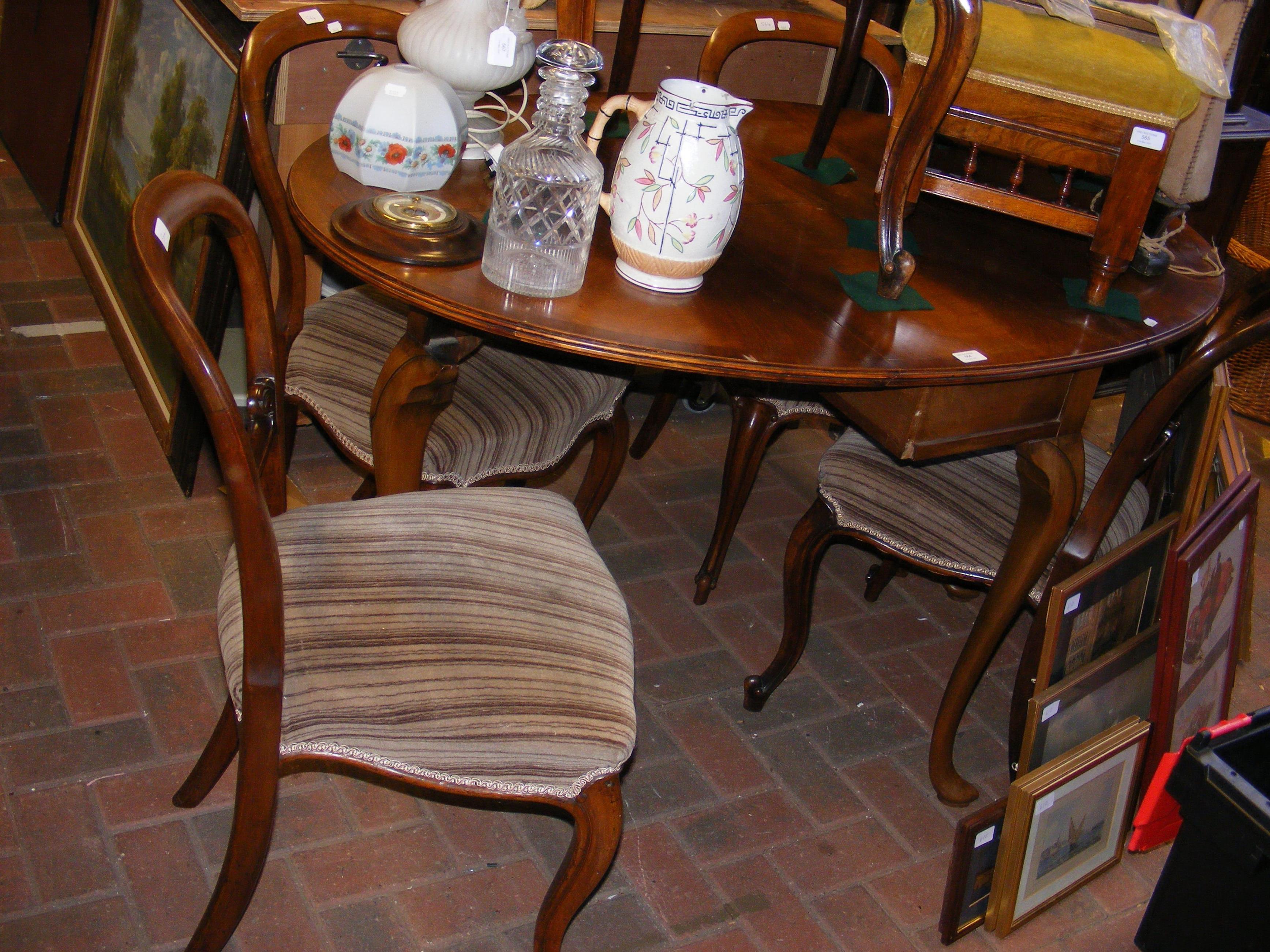 A mahogany oval gate-leg table with five balloon b