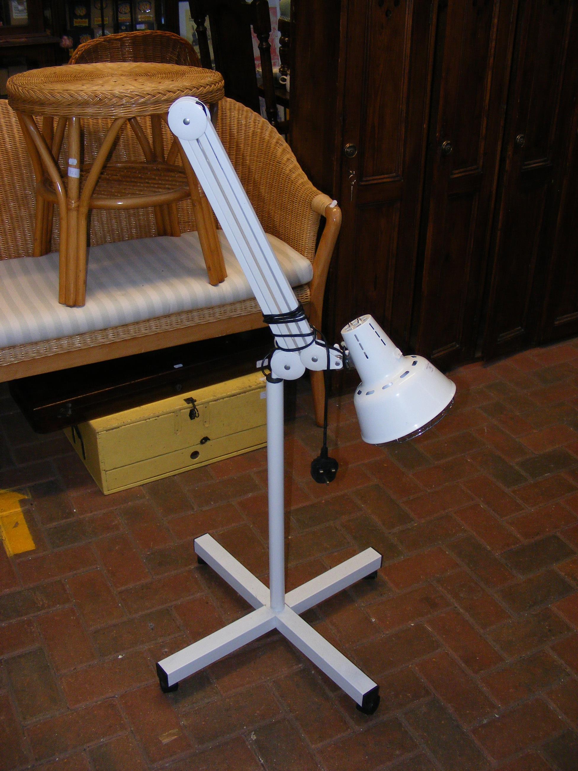 An anglepoise style lamp on stand with castors
