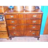 A walnut chest of four drawers with sunken brass handles