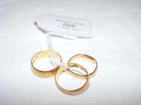 A 22ct gold wedding band together with two others