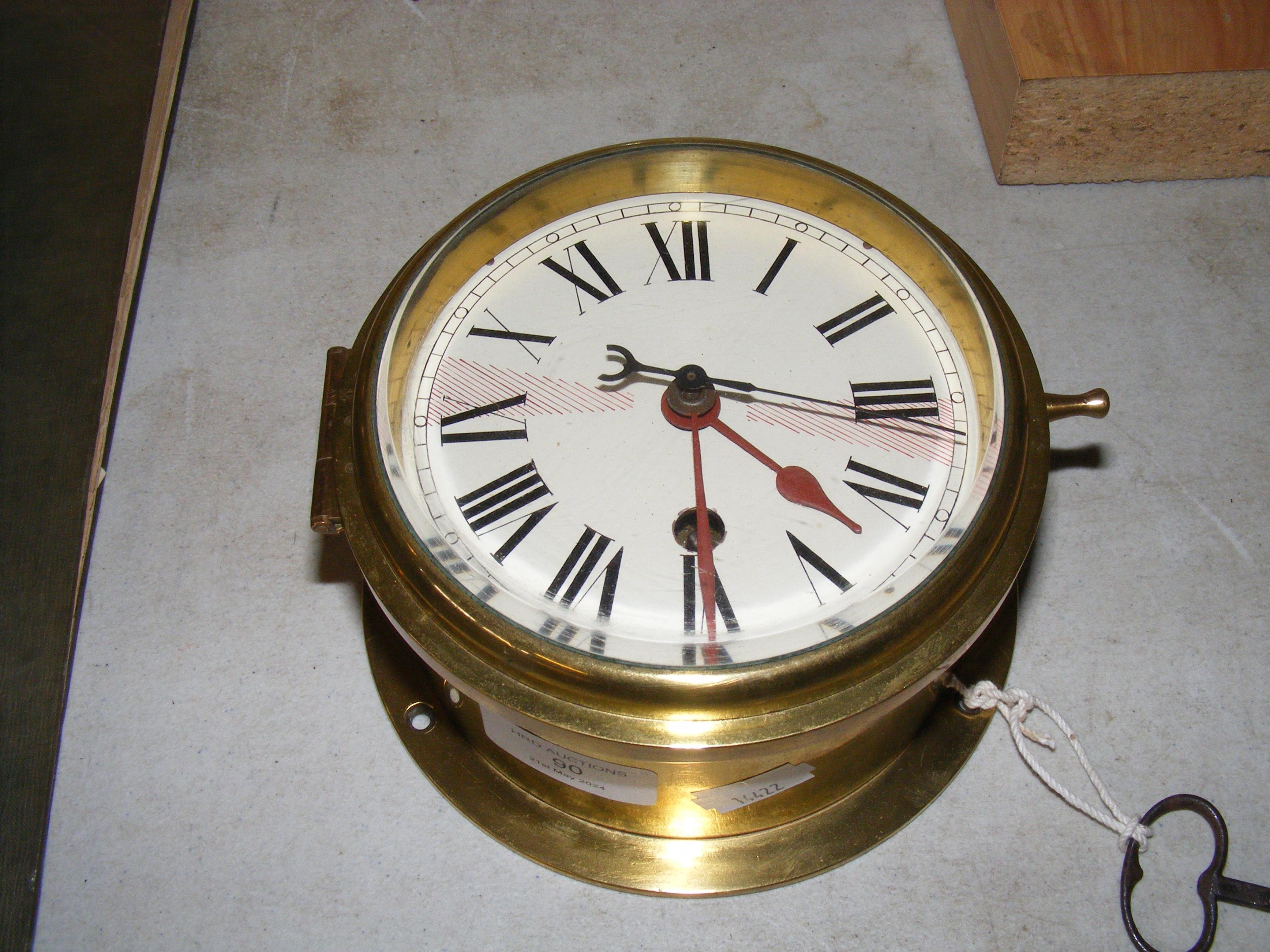 A brass cased ships baulk head clock by Pierre Deg