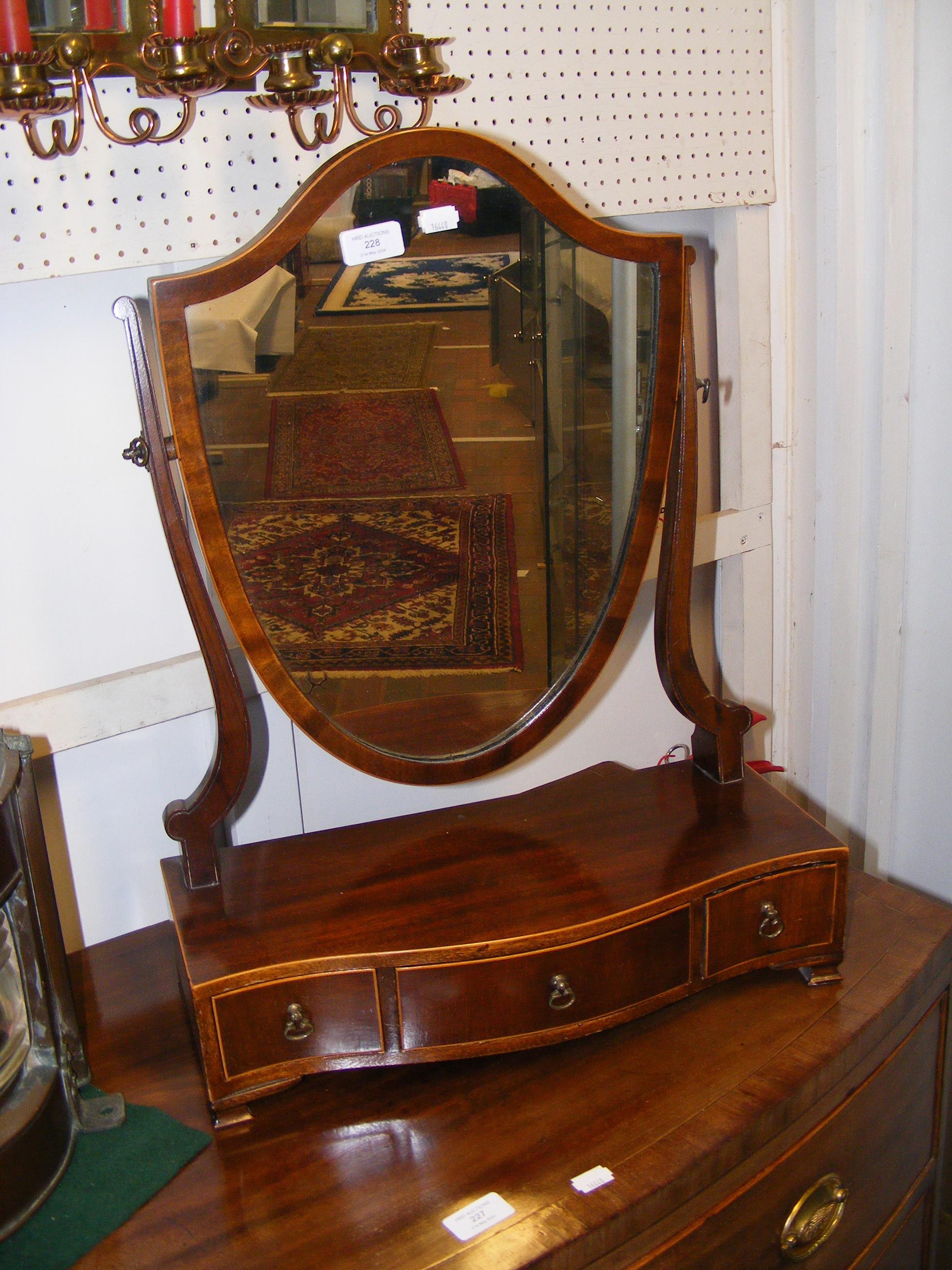 An antique toilet mirror with three drawers to the