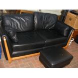 An Ercol black leather sofa with matching footstoo