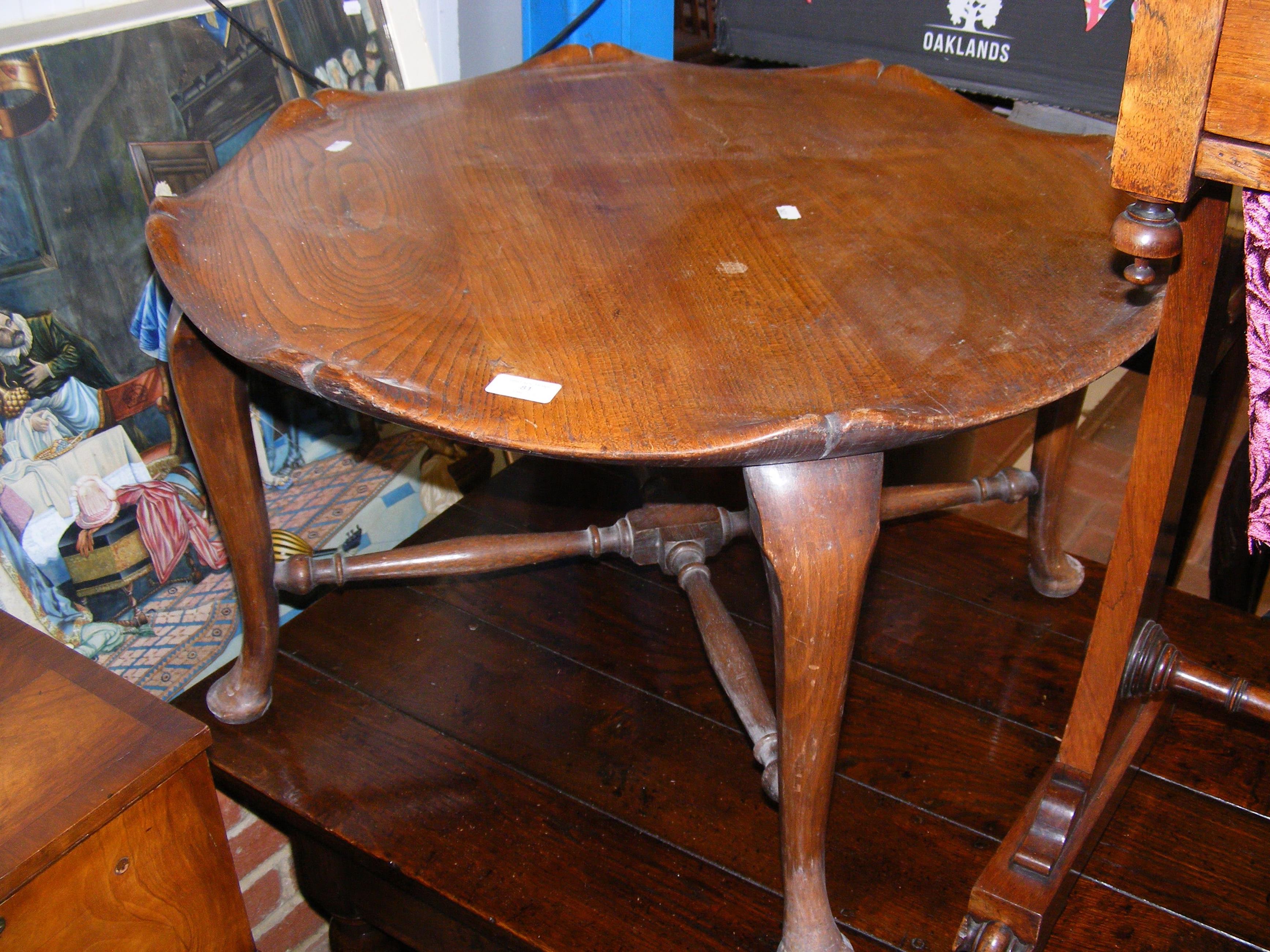 A circular wooden coffee table on cabriole support