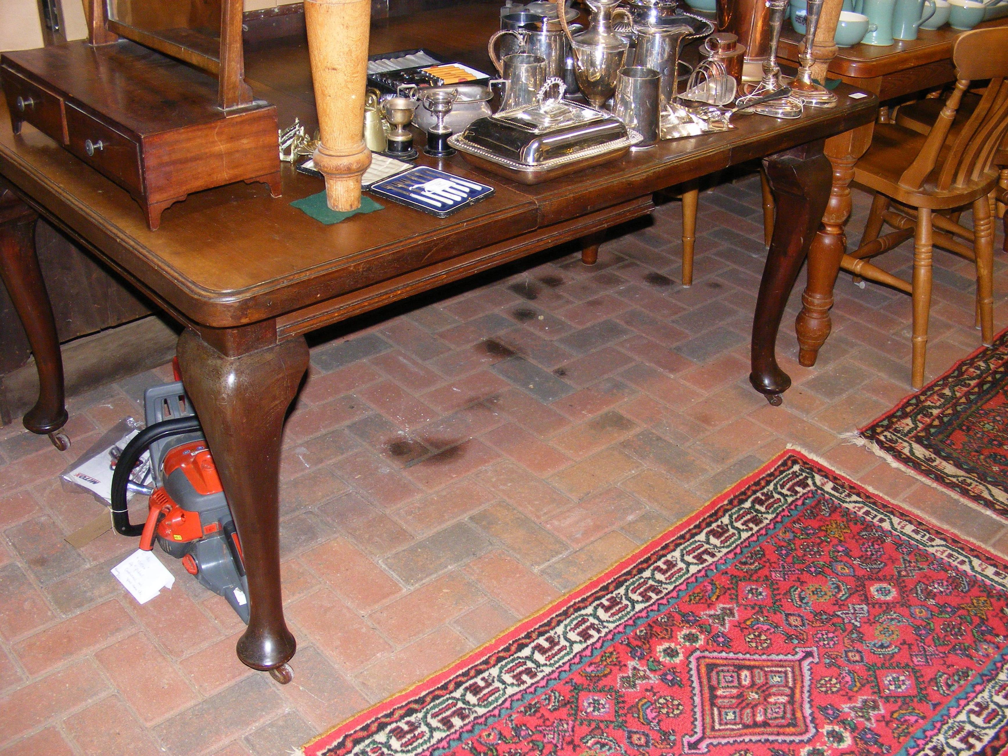 A mahogany extending dining table on cabriole supp