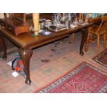 A mahogany extending dining table on cabriole supp