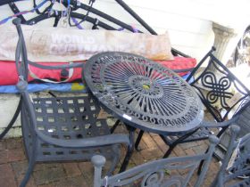 A black and metal bistro garden table with two cha