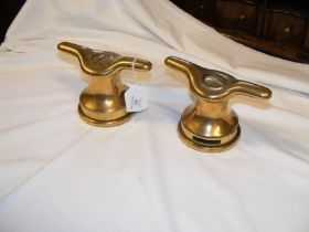 A pair of antique brass cleats, fashioned in to pa
