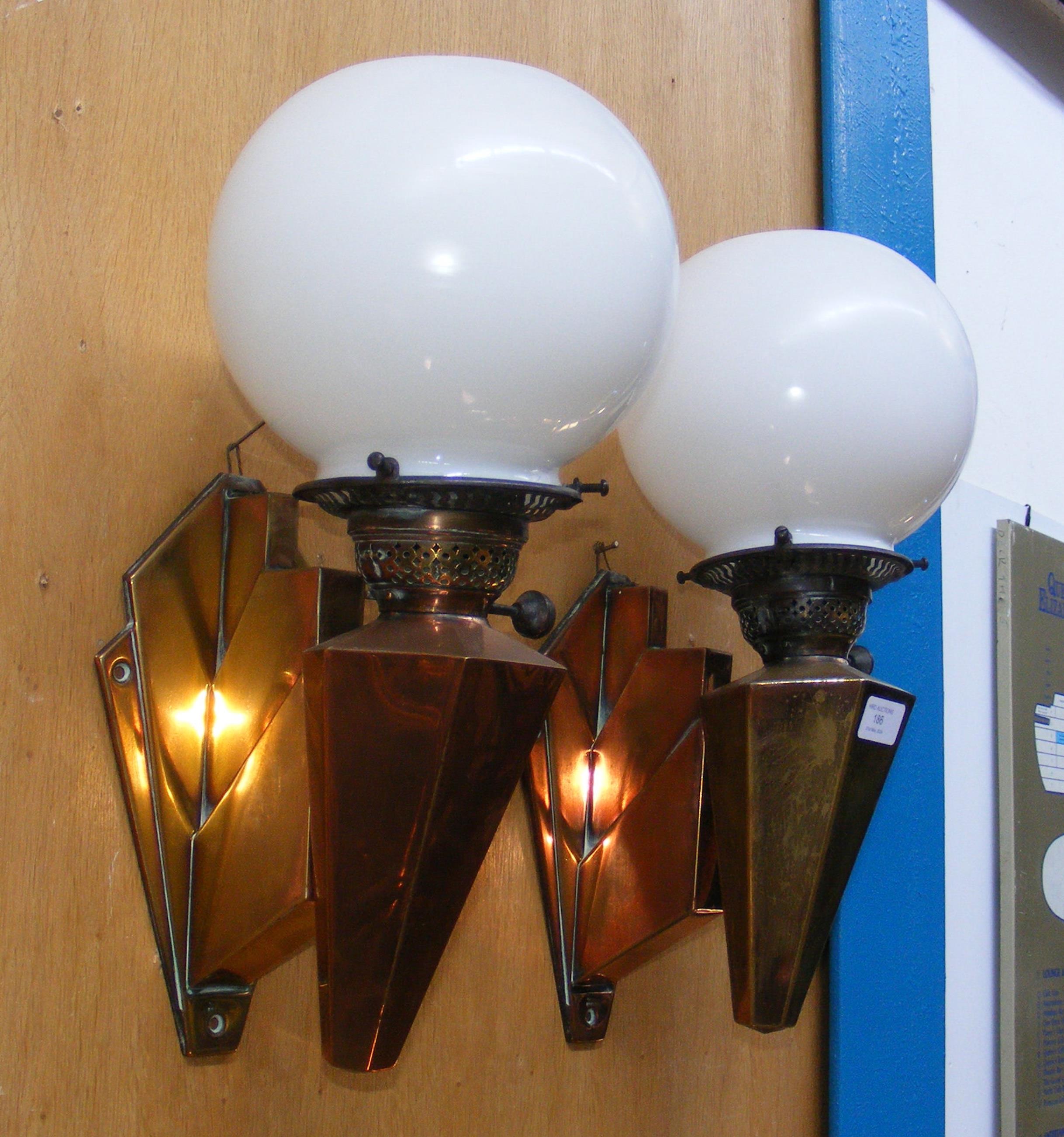 A pair of stylish Art Deco copper wall lights with