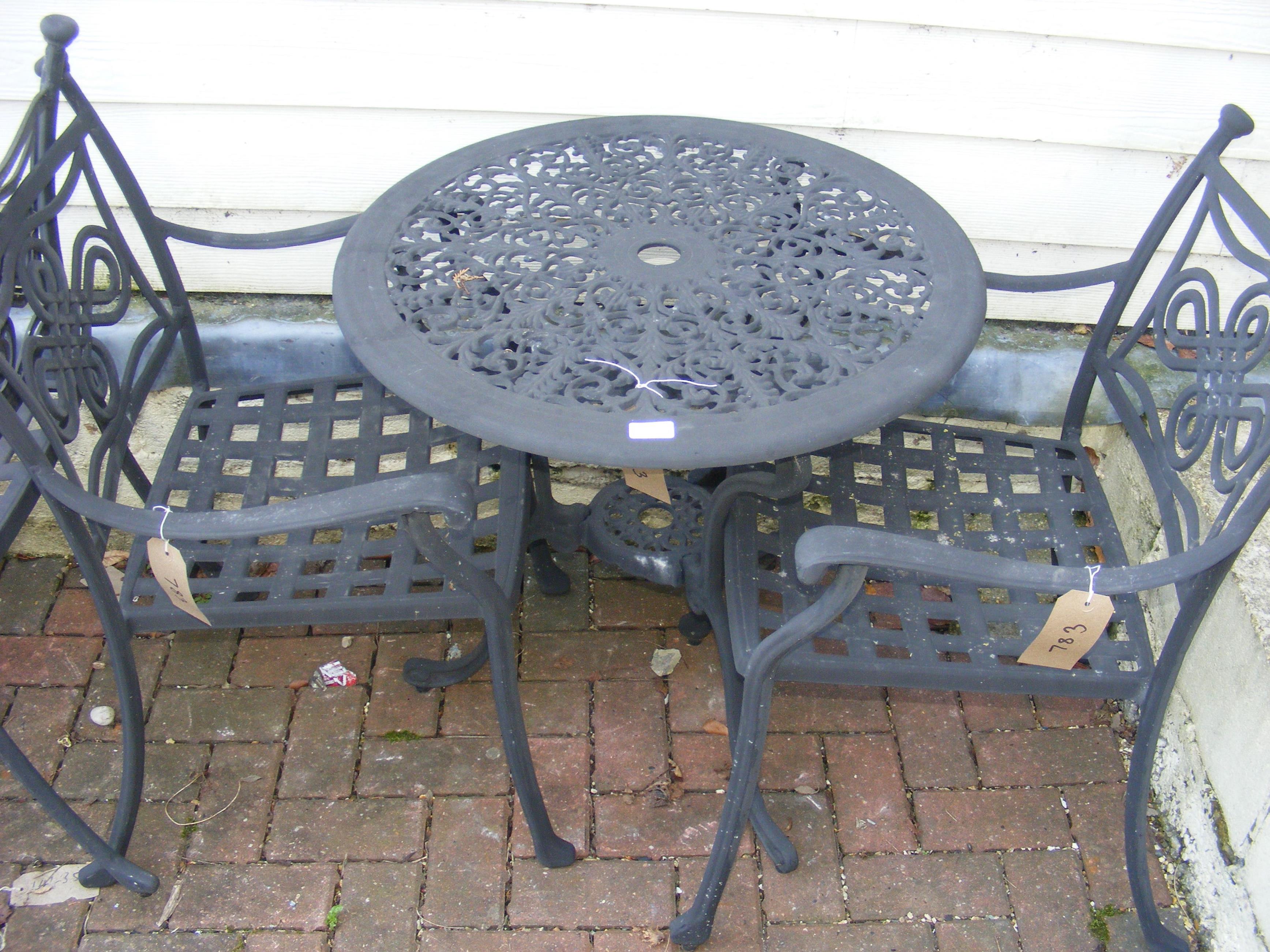 A black and metal bistro garden table with two cha