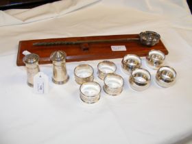 A selection of silver napkin rings, salt and peppe