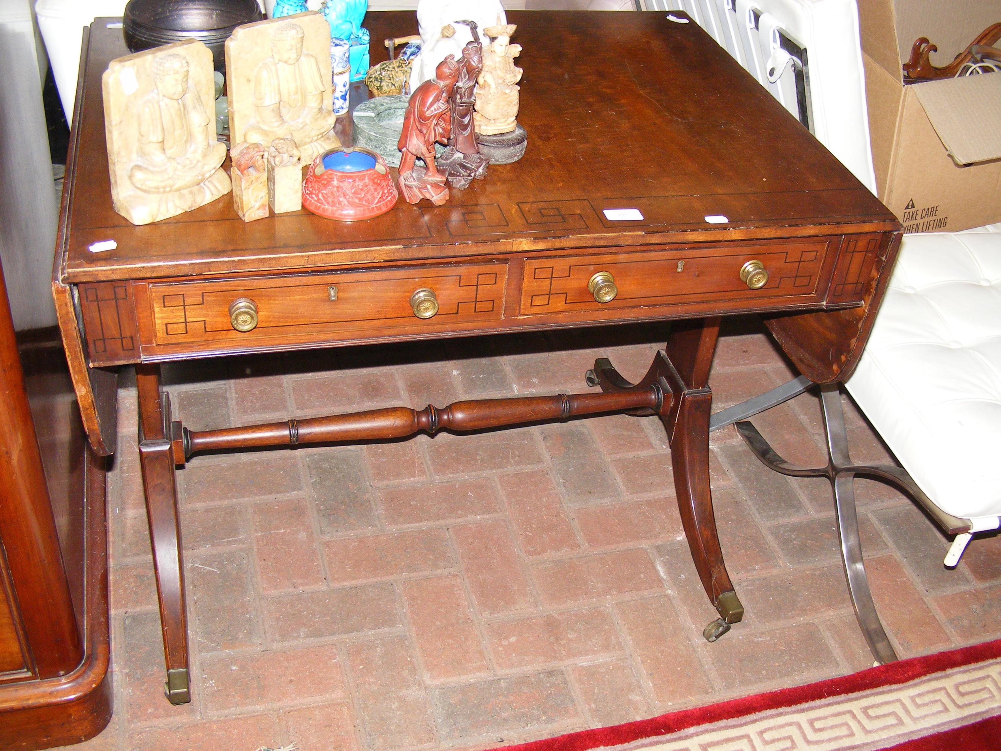 An antique mahogany sofa table with drawers to the