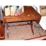 An antique mahogany sofa table with drawers to the