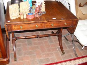 An antique mahogany sofa table with drawers to the