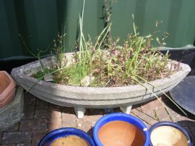 A concrete boat shaped garden trough