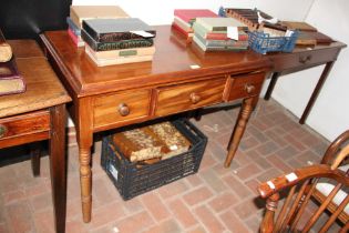 An antique mahogany three drawer side table on tur
