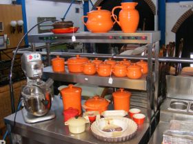 A collection of Le Creuset orange glaze ceramic wa