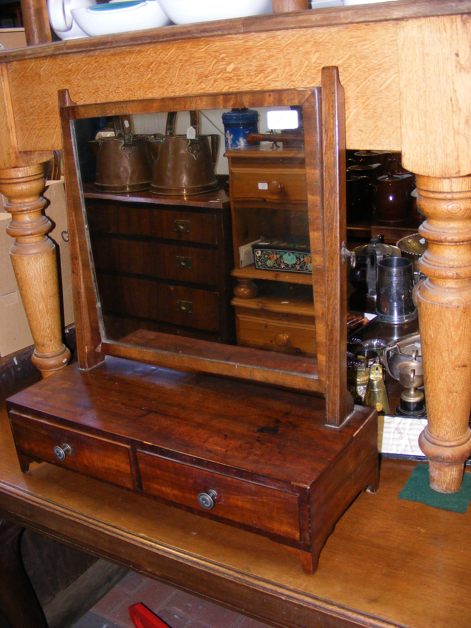 An antique toilet mirror with two drawers to the f