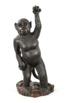 A LIFE SIZE CARVED HARDWOOD SCULPTURE OF A STANDING MONKEY