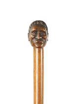 A LATE 19TH CENTURY CARVED HARDWOOD WALKING STICK FORMED AS A MĀORI