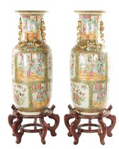 A LARGE PAIR OF 19TH CENTURY CANTON FAMILLE ROSE VASES ON STANDS