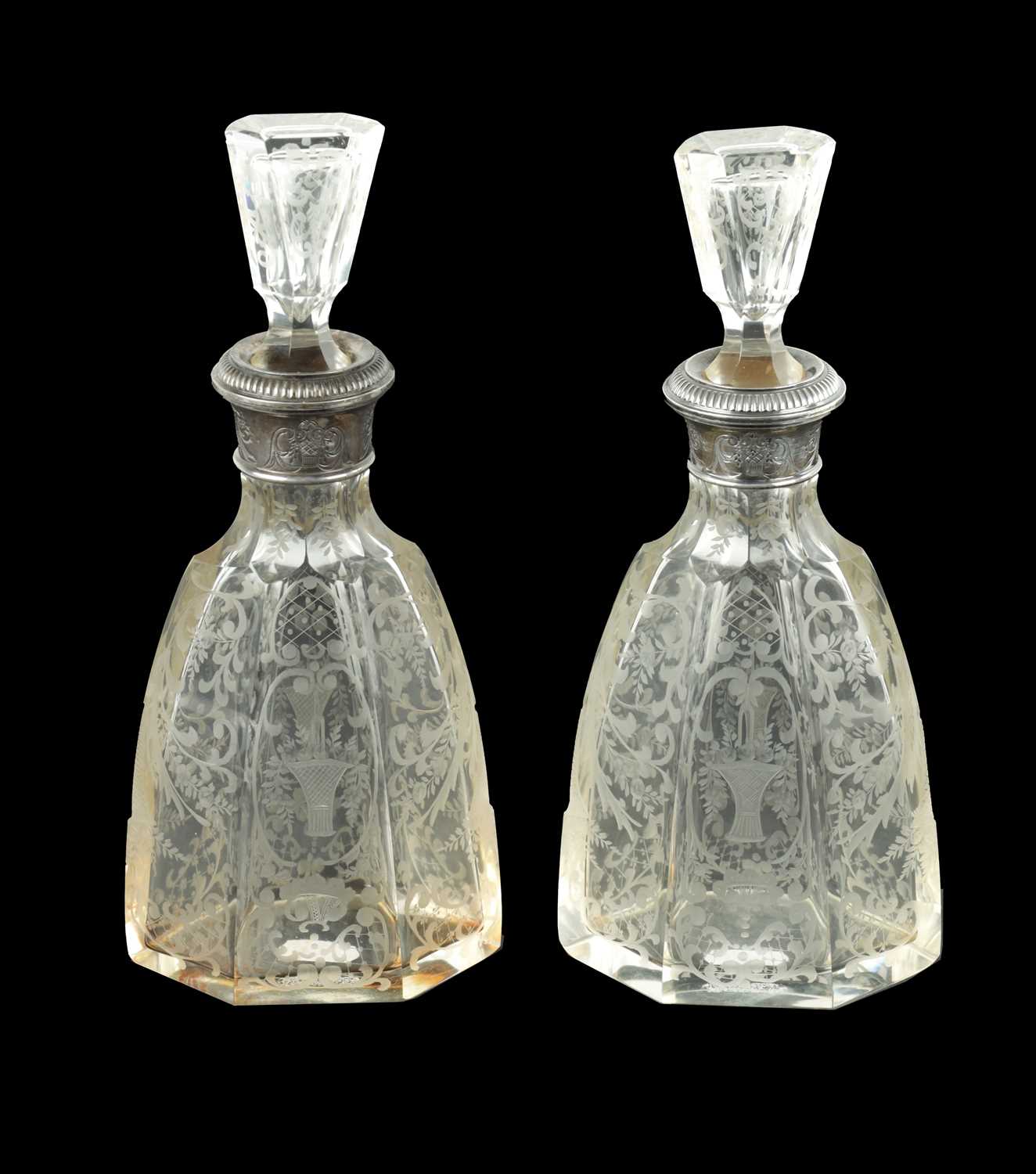 A NEAR PAIR OF 19TH CENTURY SILVER TOPPED CUT GLASS DECANTERS